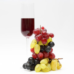 glass with red wine with grapes on a light background