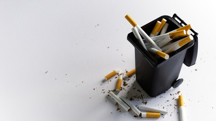 Throwing cigarettes to a trash bin quit smoking concept bad habit addiction