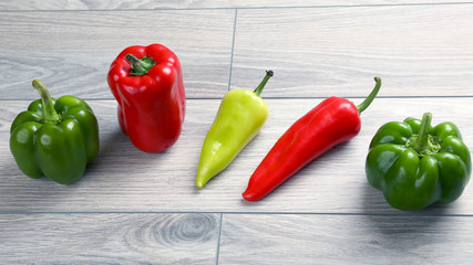 five different kinds of pepper on a wooden board