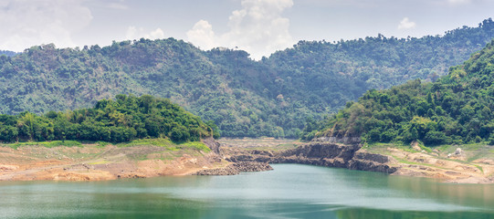Beautiful view water in lake and high mountain with blue cloudy sky behind khun dan prakan chon dam...