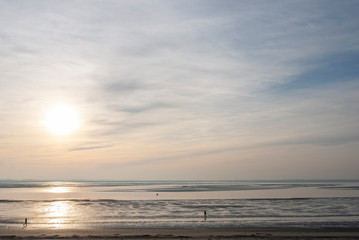 France. Baie de Somme. promeneur sur la plage de sable à marée basse sous le soleil. walker on the sandy beach at low tide under the sun.