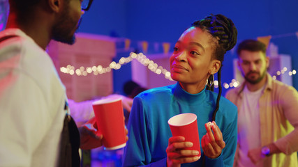 Esctatic afro-american couple of best friends enjoying fun company laughing together talking lifestyle and staying on night party celebration.
