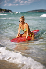 Summer portrait of slim beautiful woman with surfboard in water