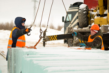 Slingers in special winter overalls for shipment of ice blocks