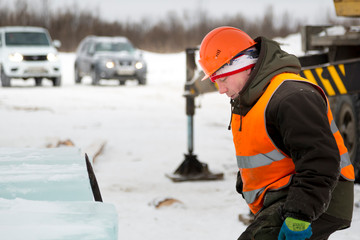 Fototapeta premium Portrait of a worker in an orange helmet at the workplace