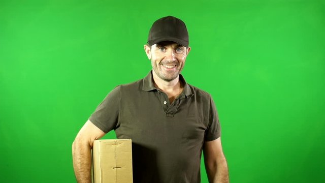 Courier / Delivery man with parcel / package smiling to the camera. Green screen Chroma key behind - Stock Video Clip Footage