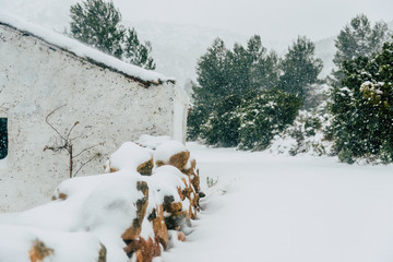 Rural house isolated in the mountains during an intense snowfall