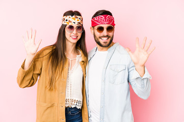 Young caucasian couple wearing a music festival clothes isolated smiling cheerful showing number five with fingers.