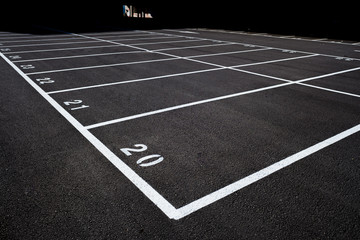 Background of the floor of an empty car park with white painted lines on the ground in a new construction.