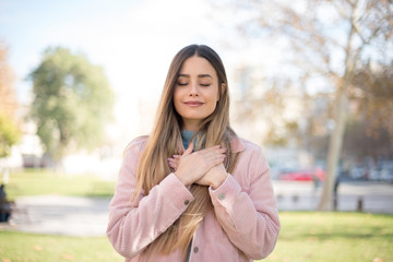 Faithful woman closes eyes and keeps hands on chest near heart, shows her kindness or favour, expresses sincere emotions, being kind hearted and honest. Body language and real feelings concept