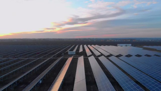 Aerial drone view into large solar panels at a solar farm at sunset. Solar cell power plants. footage video 4k.
