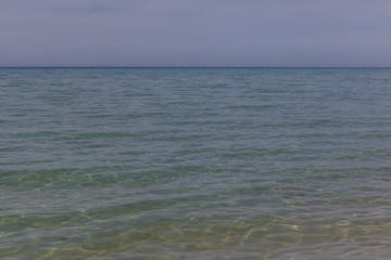 View of blue sea waves at sandy beach. Horizon line. Caspian Sea, sandstone coast. ustyurt. Selective focus, long shutter speed