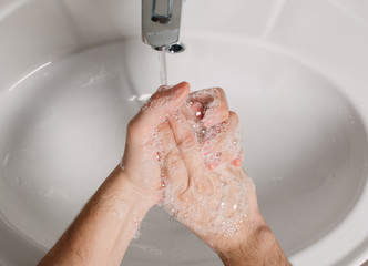 Wash hands under the tap with soap. Hygiene concept in detail. Beautiful stream of hands and water...