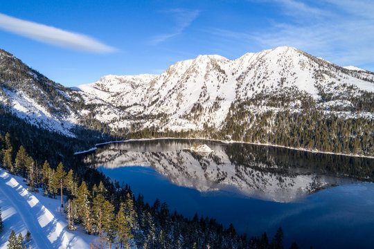 A beautiful aerial winter view of Emerald Bay at sunrise with Jake's Peak reflecting in the calm water of Lake Tahoe, California.