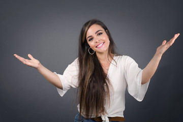 Cheerful woman making a welcome gesture raising arms over head isolated on white background.