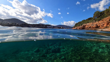Fototapeta na wymiar Split underwater photo of exotic island cave with rocky emerald seascape