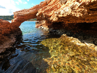 Split underwater photo of exotic island cave with rocky emerald seascape