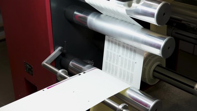Close up Large offset printing press. moving polymer label conveyor typography facility and flexographic printing