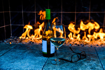 Obraz premium wine bottle and glass on a outdoor fireplace.