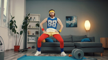 Sexy sportive young man in retro outfit enjoying music dancing and warming up preparing for intense...