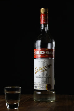 Aura, Finland - April 14, 2019: Bottle of Stolichnaya, also known as Stoli is a russian vodka made of wheat and rye grain. Also shot glass filled with vodka.