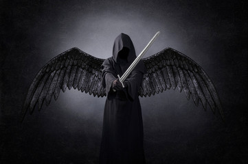Dark angel with medieval sword in the dark