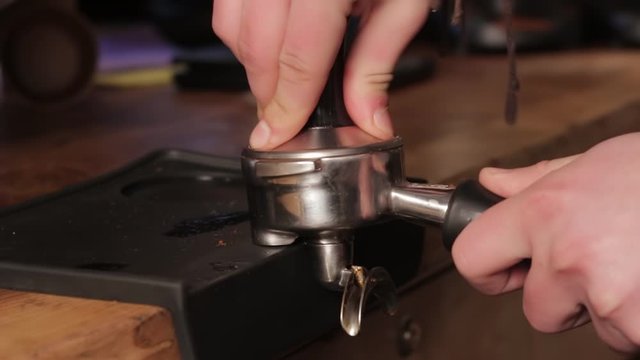 Making ground coffee with tamping fresh coffee. Professional barista.