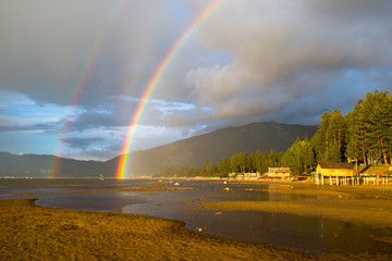 A double rainbow appears after an afternoon thunderstorm over South Lake Tahoe with Heavenly Mountain Resort in the background, California.
