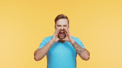 Expressive young man screaming and shouting over vibrant background. Portrait of handsome person.