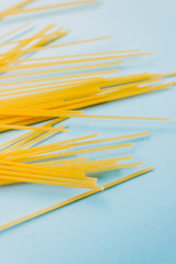 Wheat pasta spaghetti isolated on a blue background. top view