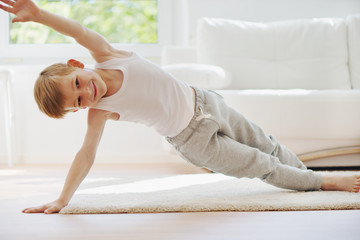 Happy little  boy exercising at home
