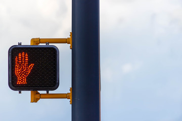 A black light pole with a pedestrian crossing light attached.