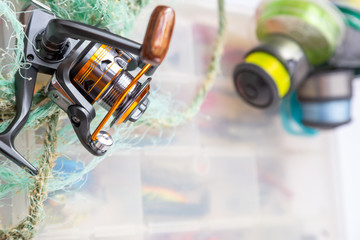 Different fishing tackles, lines and reel on wooden cork background.