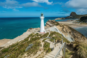 Fototapeta na wymiar White lighthouse on a cliff during sunny day