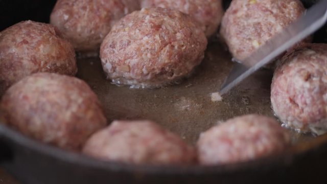 Home cooking. Roasting the meatballs in sunflower oil in a cast iron skillet.