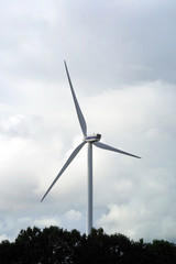 Wind stations. Windmills for electricity production. Wind turbines generating electricity against a cloudy blue sky. Energy saving concept.