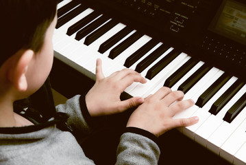 The hands of a child playing the piano
