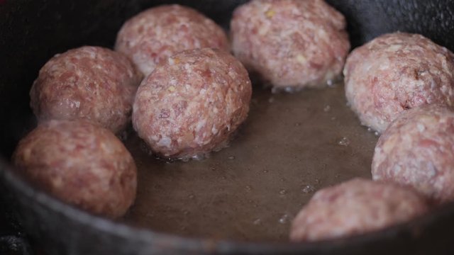 Home cooking. Roasting the meatballs in sunflower oil in a cast iron skillet.