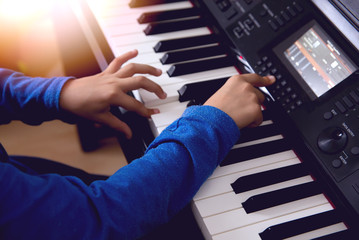 The hands of a child playing the piano
