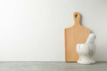 Wooden board and mortar on brown table against white background, space for text