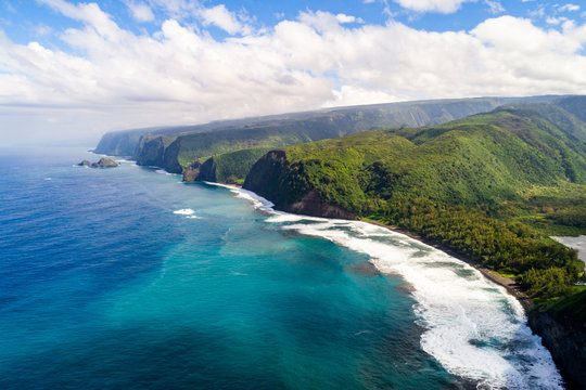 An aerial view looking down the stunning coastline of the Big Island of Hawaii. The first valley on the right is the famous Pololu Valley.