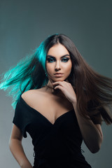 Naklejka premium Beautiful sexy woman with long brown hair. Pretty model poses at studio. Fashion Model Girl Portrait with Long Blowing Hair. Glamour Beautiful Woman with Healthy and Beauty Brown Hair