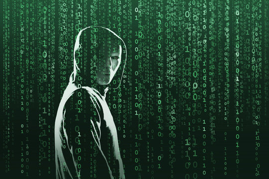 Computer hacker in mask and hoodie over abstract binary background. Obscured dark face. Data thief, internet fraud, darknet and cyber security.