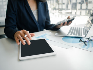 Business woman hand working at a computer, using calculator and laptop to calculate an account. Finance and accounting concept.