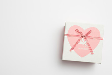 Greeting card for Valentine's Day. Cardboard box with a pink heart for gifts, tied with a rope.