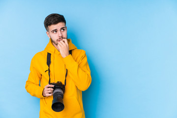 Young caucasian photographer man isolated relaxed thinking about something looking at a copy space.