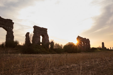 ruínas de aqueduto romano para passagem de água com por do sol