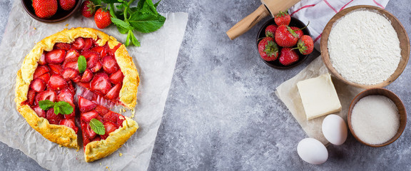 Banner for website. Summer Galette with strawberry and ingredients for cooking gaette on the gray concrete stone background. Top view, flat lay, copy space