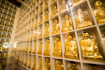 A detail of one of the walls of the Jeweled Hall of 10,000 Buddhas that is lined with golden statues in the City Of Ten Thousand Buddhas in Ukiah, California.