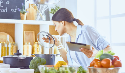 Image of a young pretty girl standing in the kitchen and is coo